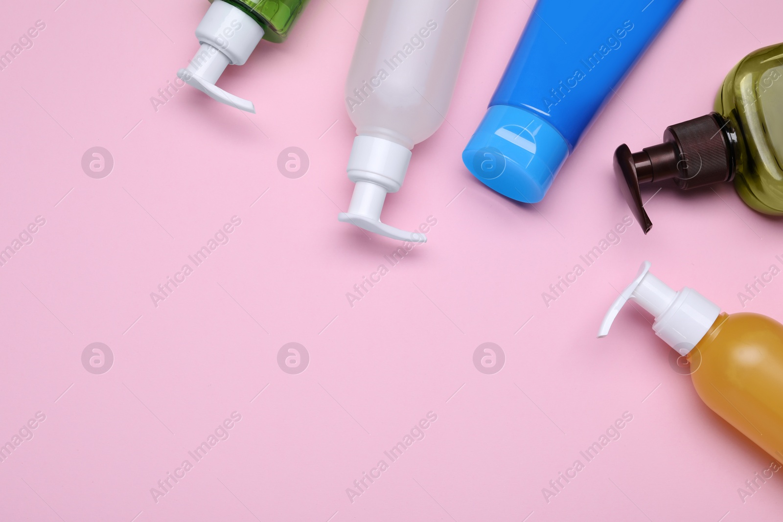 Photo of Different cleansers on pink background, flat lay with space for text. Cosmetic product