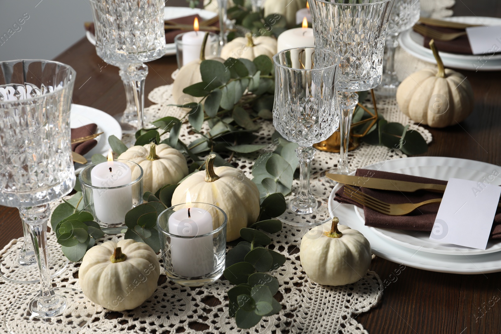 Photo of Beautiful autumn table setting. Plates, cutlery, glasses, blank cards and floral decor