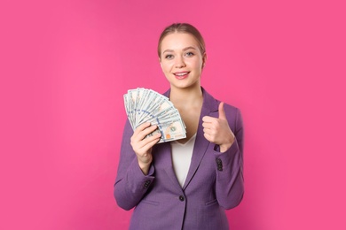 Photo of Portrait of happy young businesswoman with money on color background