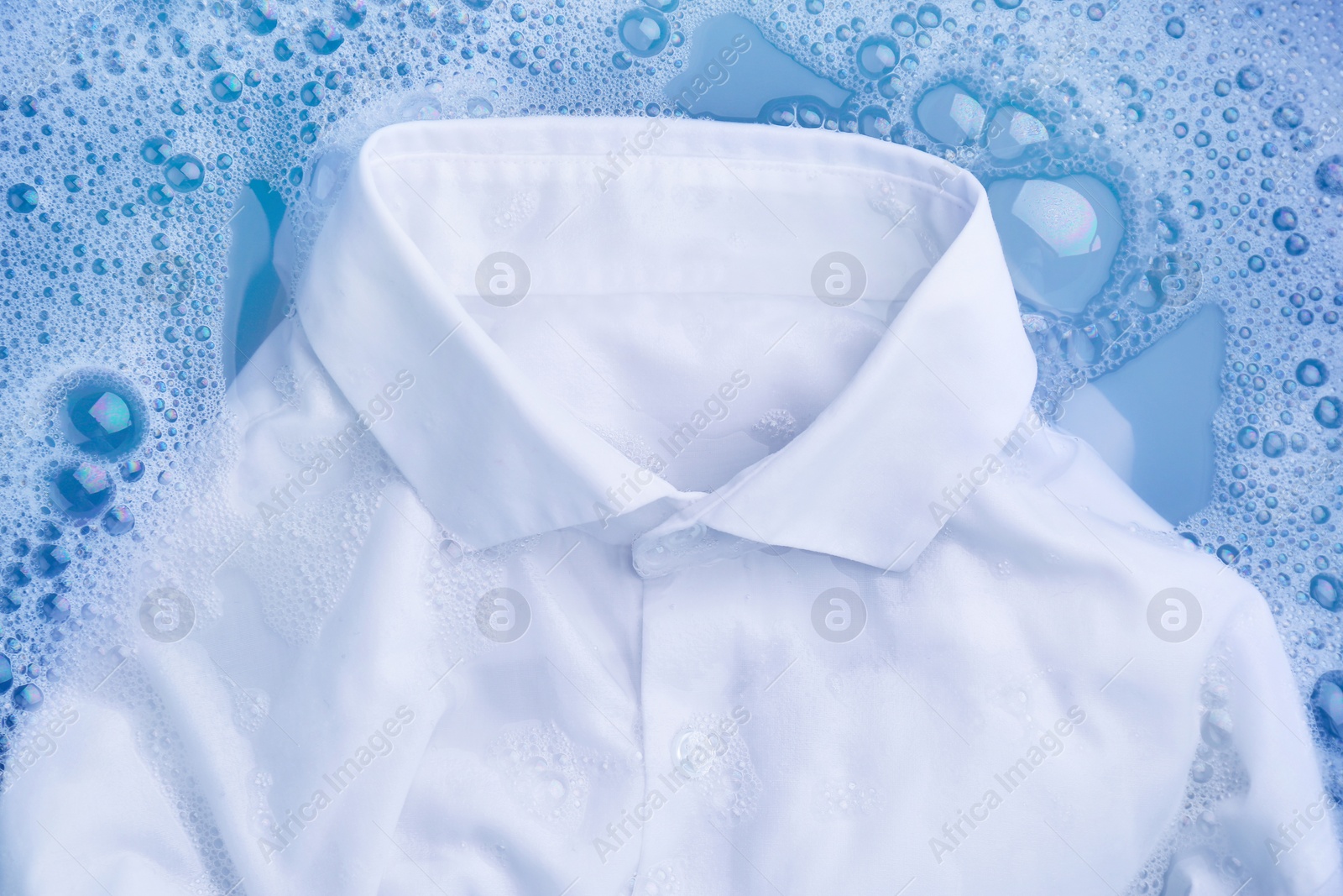 Photo of White clothing in suds, top view. Hand washing laundry