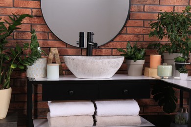 Photo of Stylish sink and beautiful green houseplants in bathroom. Interior design