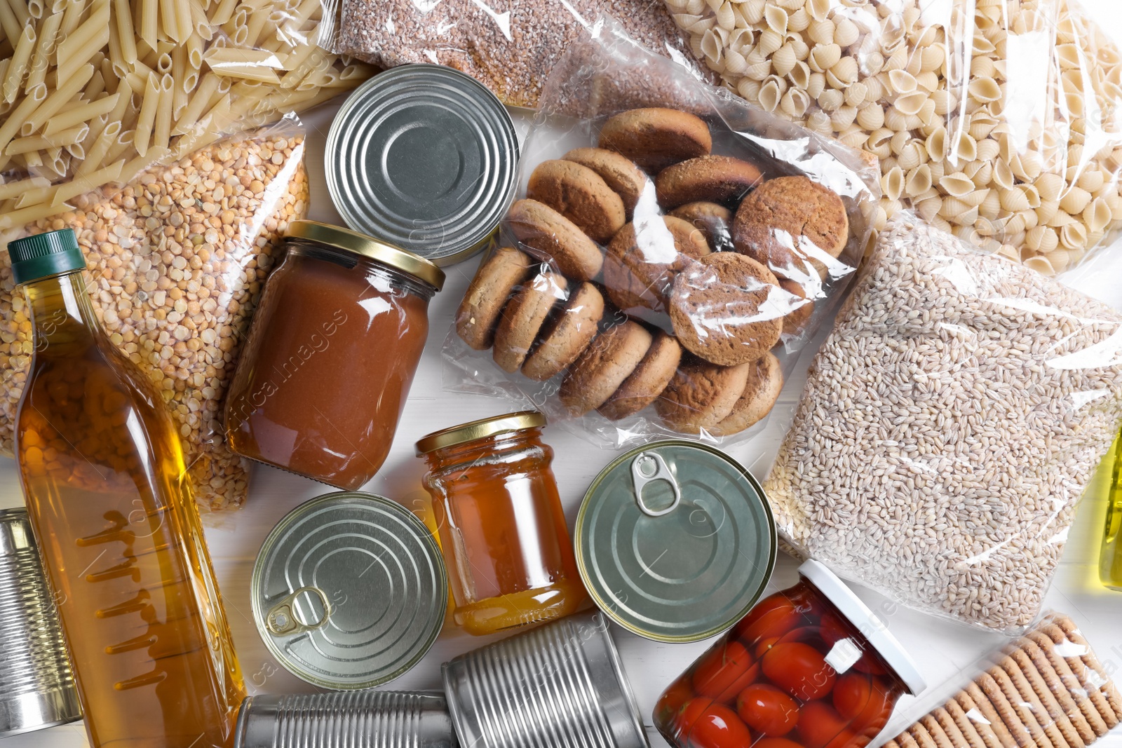 Photo of Different products on white wooden table, flat lay. Food donation