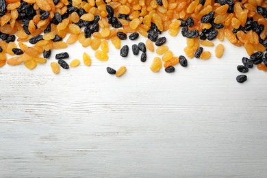 Photo of Raisins on wooden background, top view with space for text. Dried fruit as healthy snack