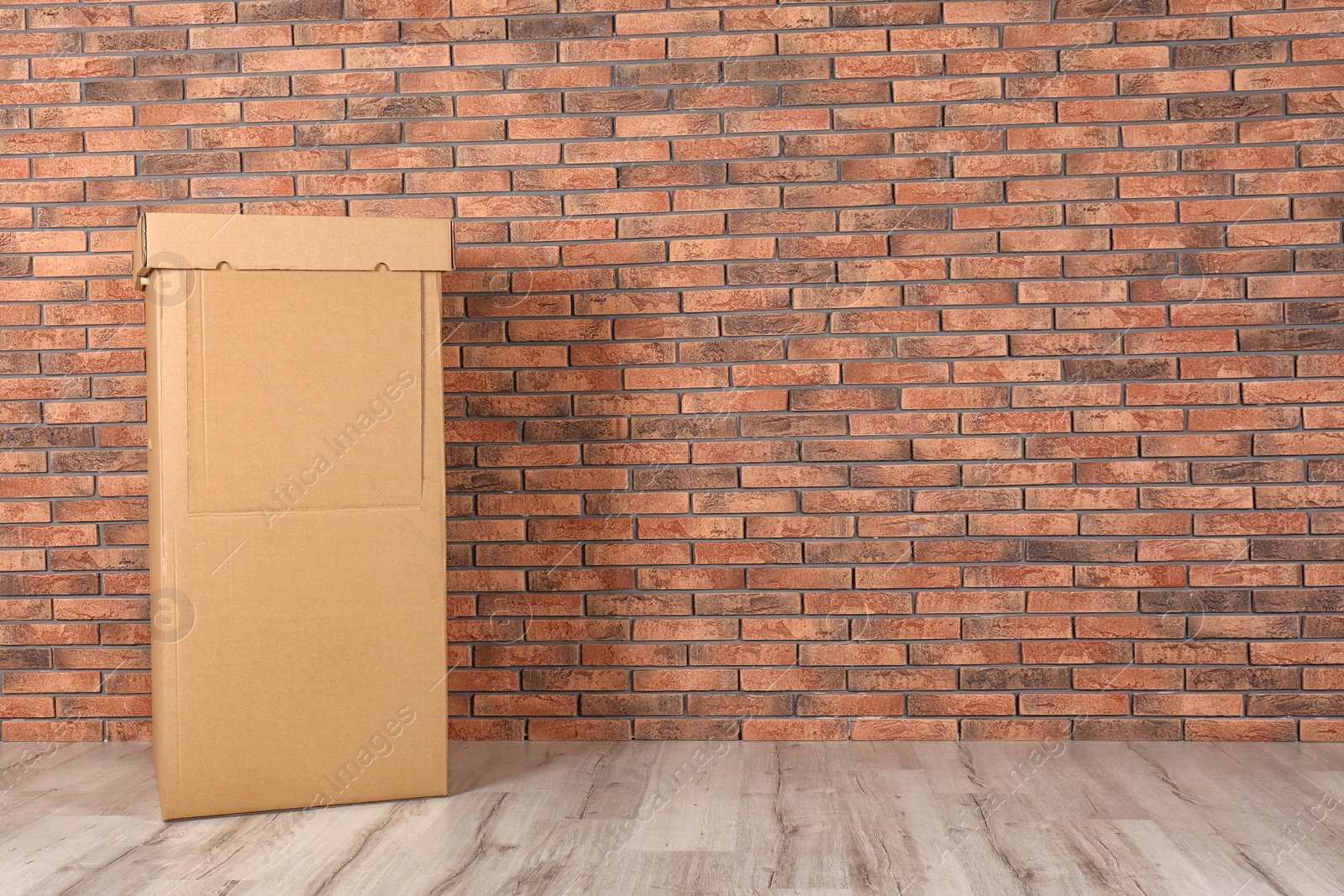 Photo of Wardrobe box against brick wall indoors. Space for text