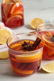 Photo of Aromatic punch drink and ingredients on white wooden table