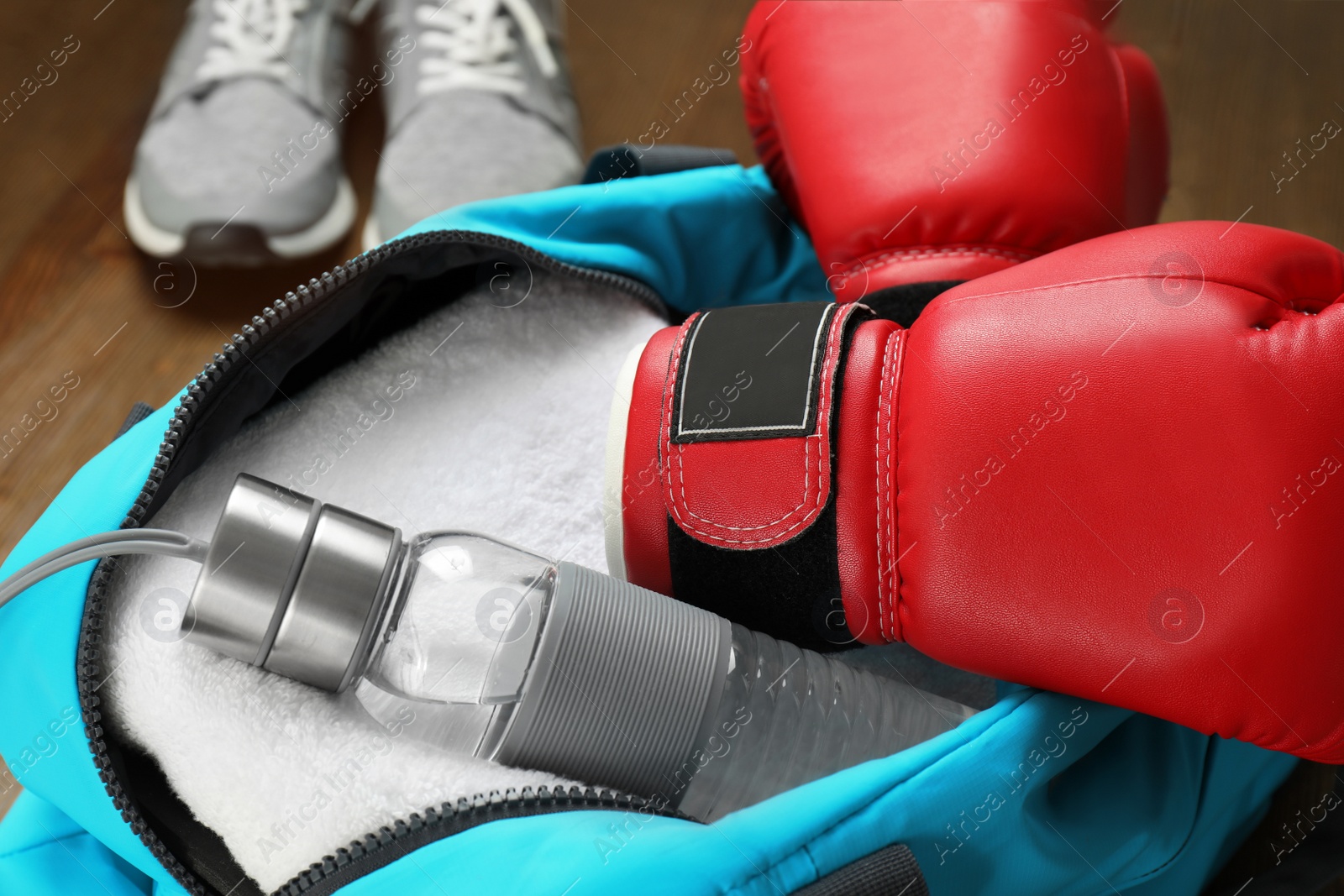 Photo of Open sports bag with gym equipment, closeup