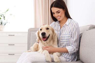 Young woman and her Golden Retriever dog in living room