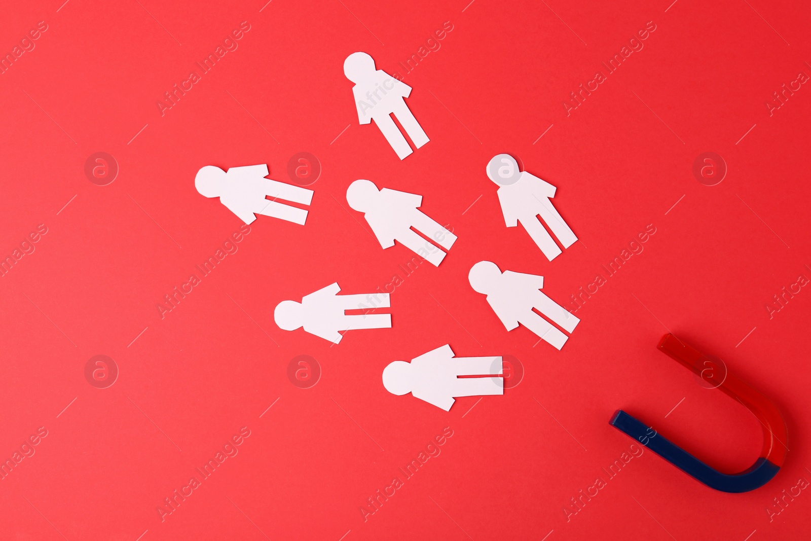 Photo of Magnet and paper people on red background, flat lay