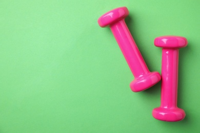 Bright dumbbells and space for text on color background, flat lay. Home fitness