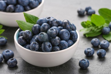 Photo of Tasty fresh blueberries on grey table, closeup