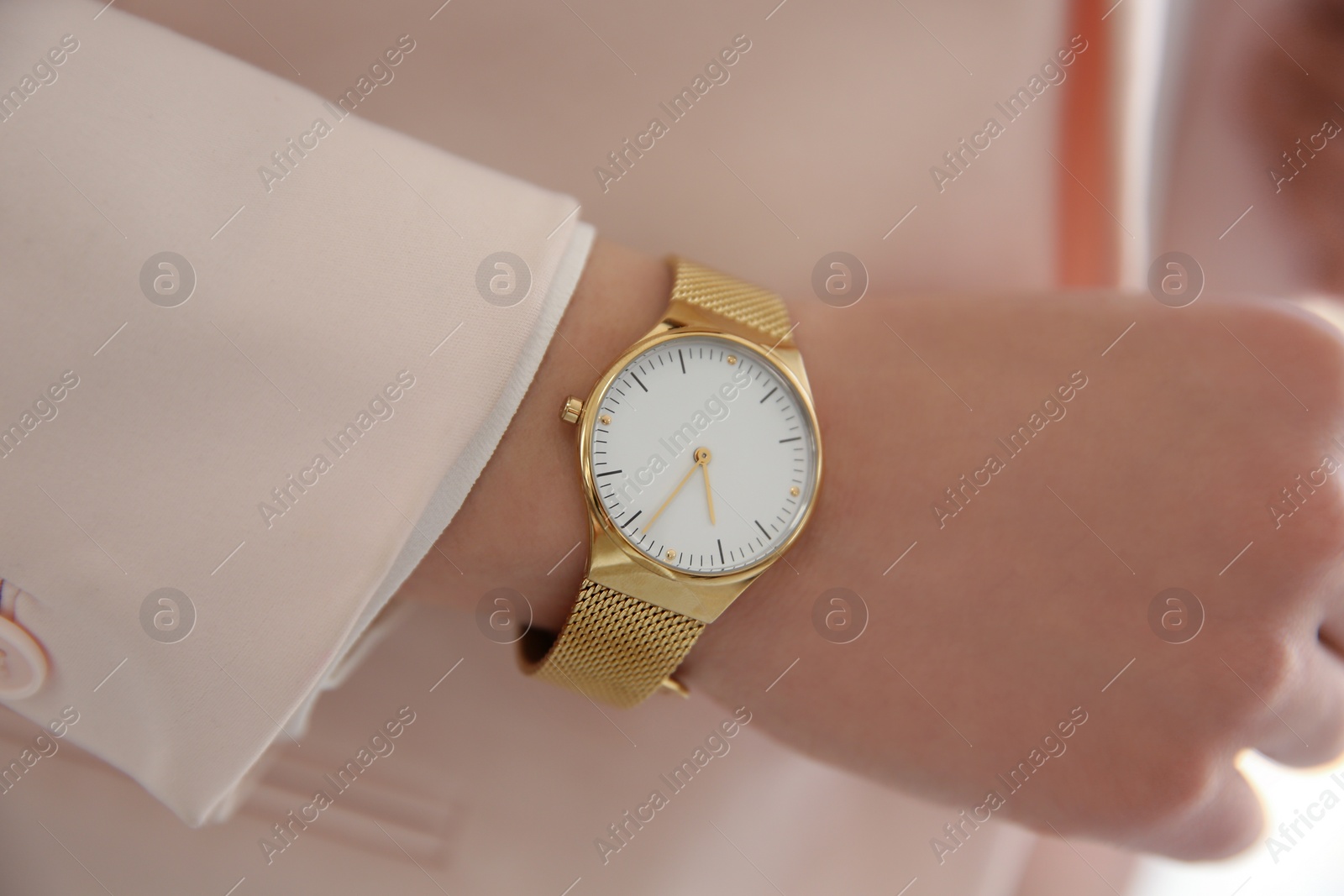 Photo of Woman in pink jacket with luxury wristwatch, closeup