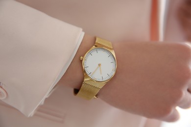 Woman in pink jacket with luxury wristwatch, closeup