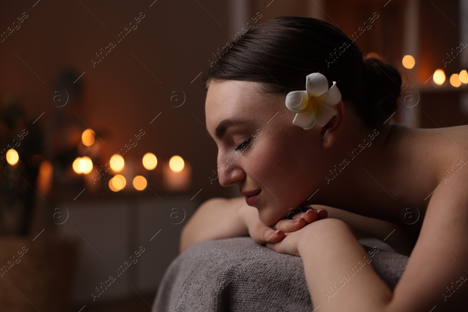 Photo of Spa therapy. Beautiful young woman lying on massage table in salon, space for text