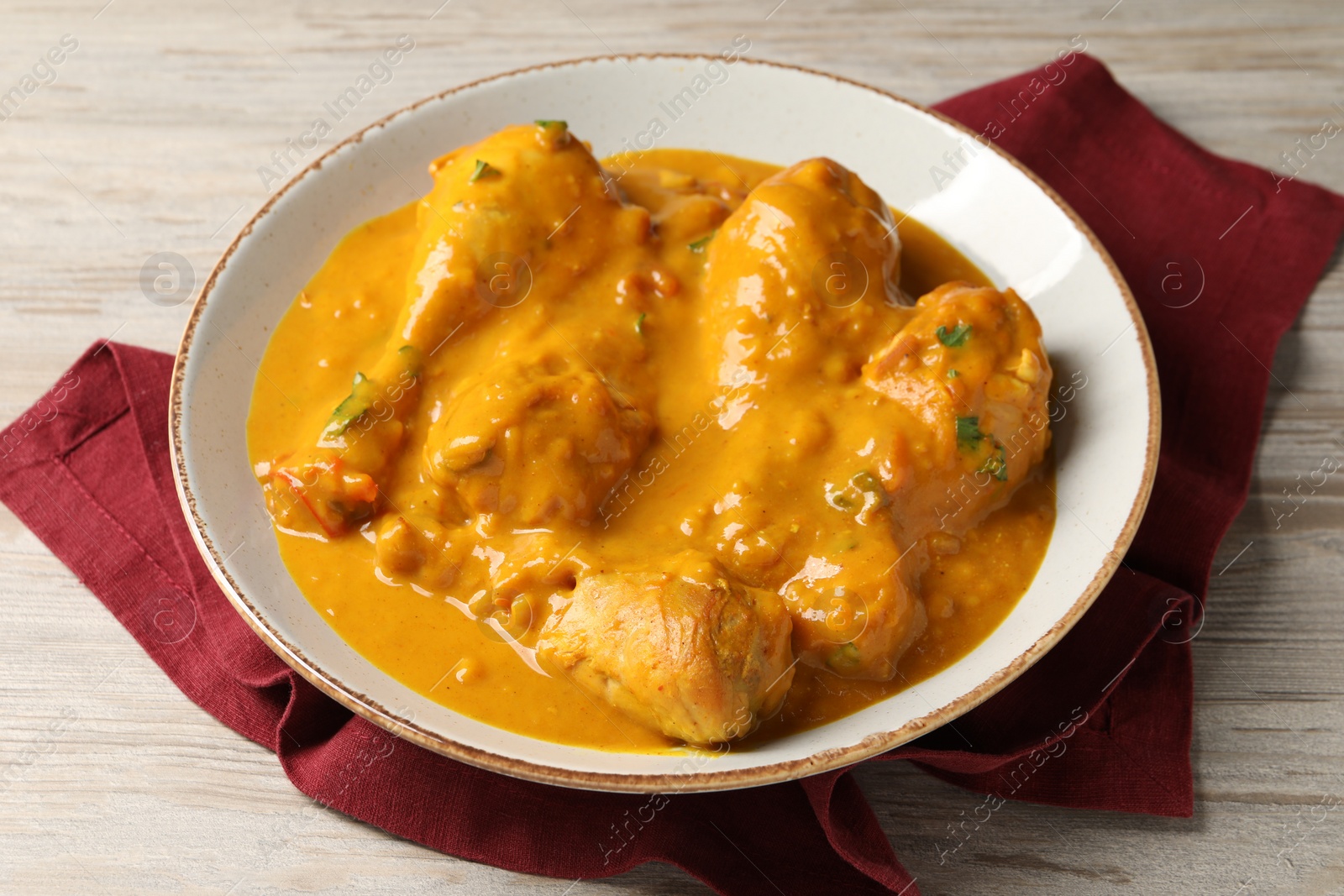 Photo of Tasty fresh chicken curry on wooden table