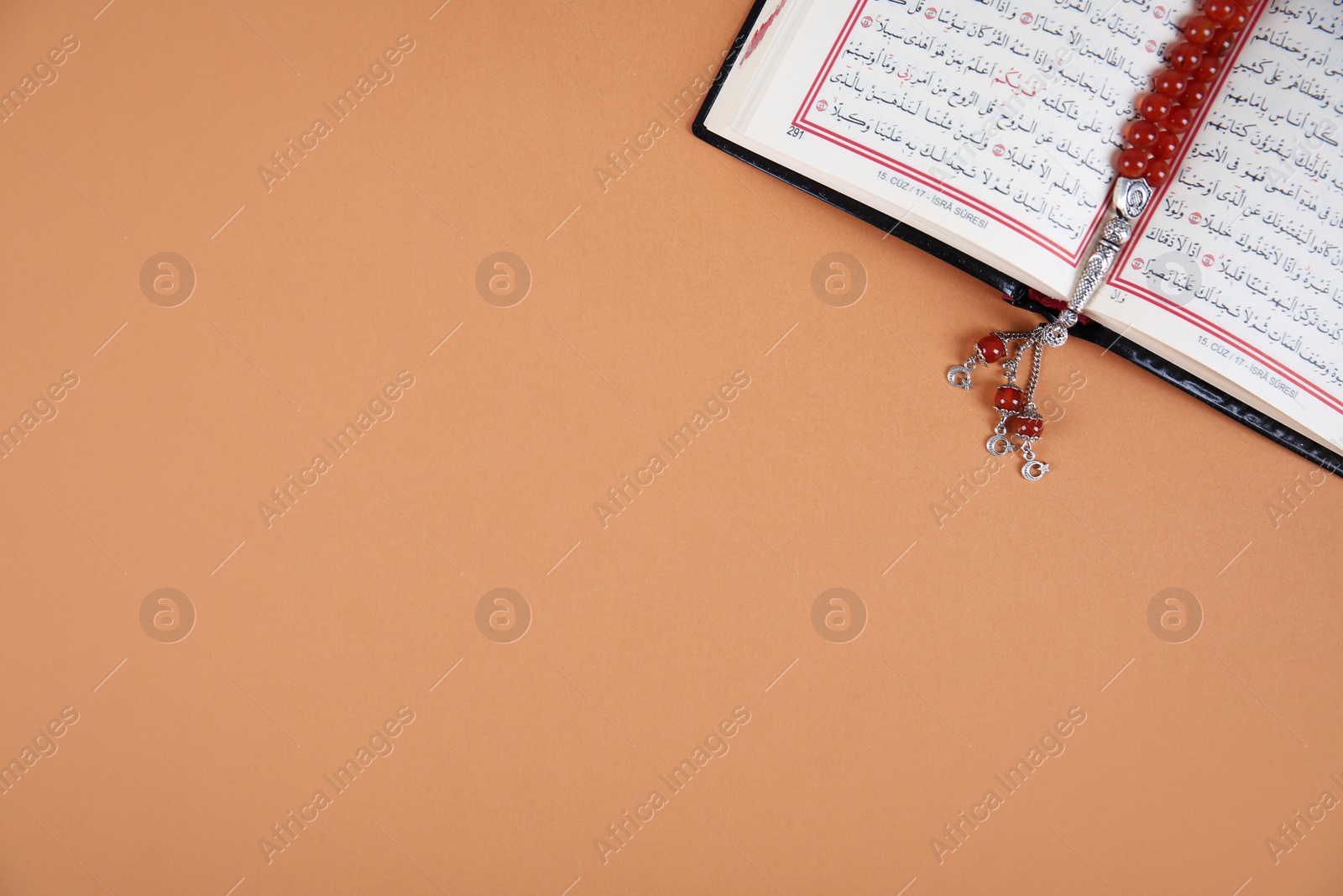 Photo of Muslim prayer beads, Quran and space for text on color background, top view