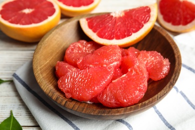 Plate with fresh peeled grapefruit on table