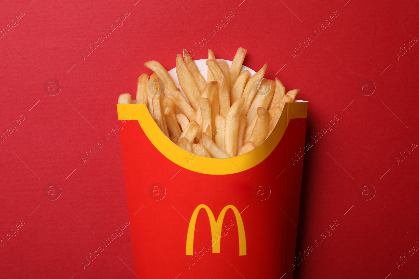 Photo of MYKOLAIV, UKRAINE - AUGUST 12, 2021: Big portion of McDonald's French fries on red background, top view