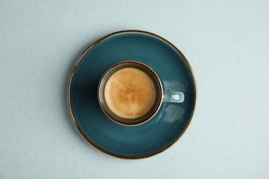 Cup of hot aromatic espresso on light background, top view