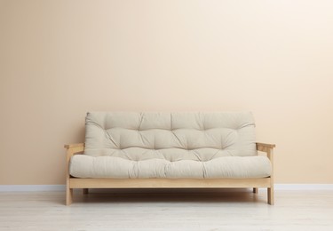 Photo of Comfortable sofa near beige wall on floor indoors