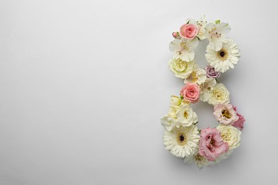 Photo of Number 8 made of beautiful flowers on white background, flat lay with space for text. International Women's day