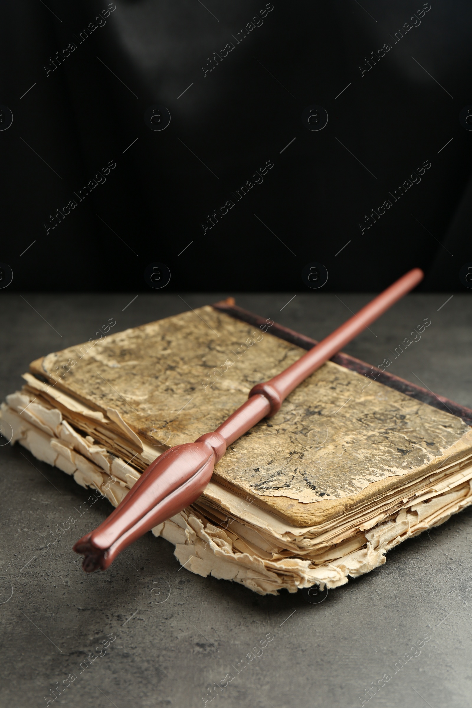 Photo of Magic wand and old book on light grey table