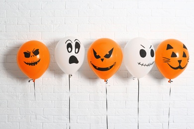 Photo of Color balloons for Halloween party against white brick wall