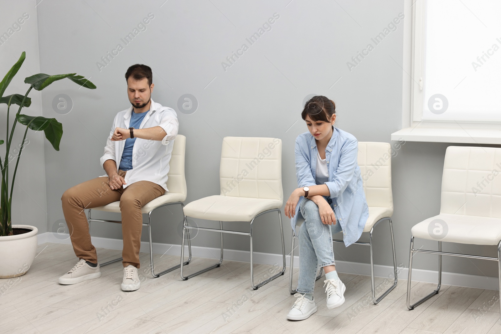 Photo of Man and woman waiting for appointment indoors