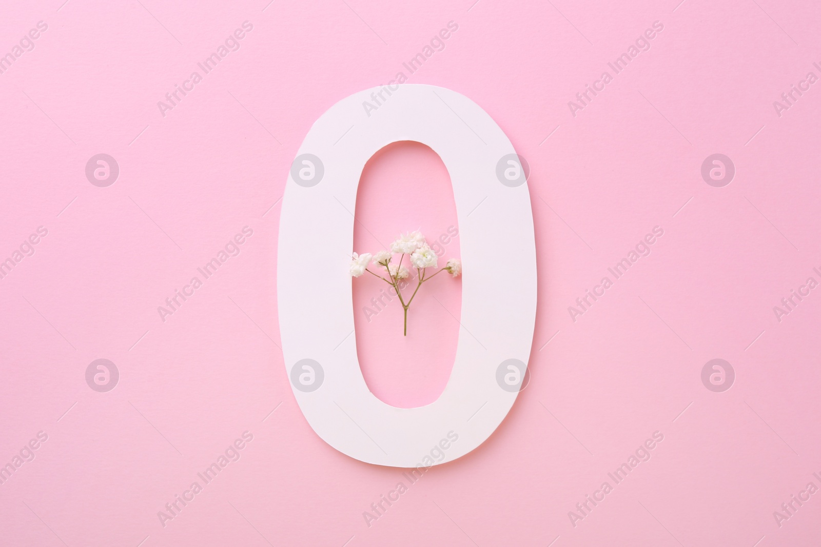 Photo of Paper number 0 and beautiful gypsophila flower on pink background, top view