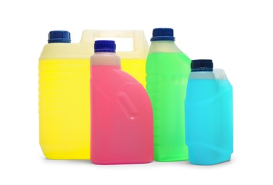 Plastic canisters with different liquids for car on white background