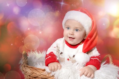 Cute baby in wicker basket on red background. Magical Christmas atmosphere
