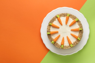 Photo of Dish with tasty carrot cake on color background, top view. Space for text