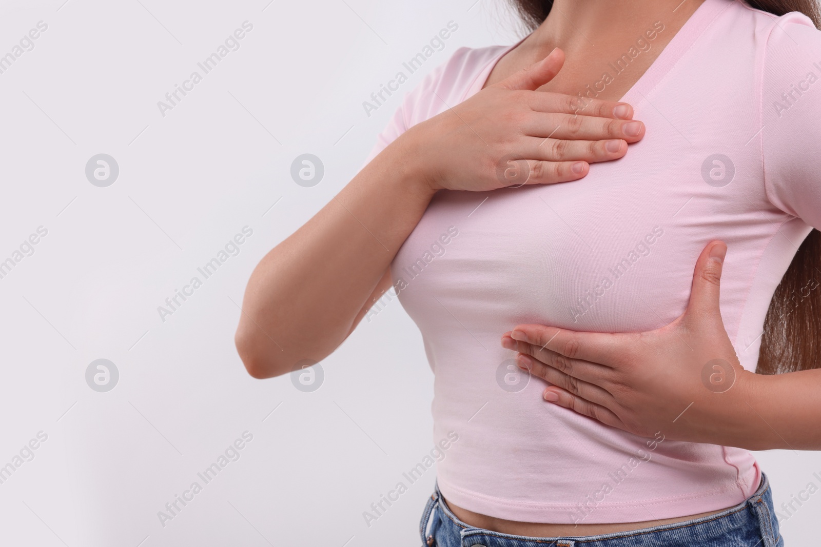 Photo of Woman doing breast self-examination on white background, closeup. Space for text