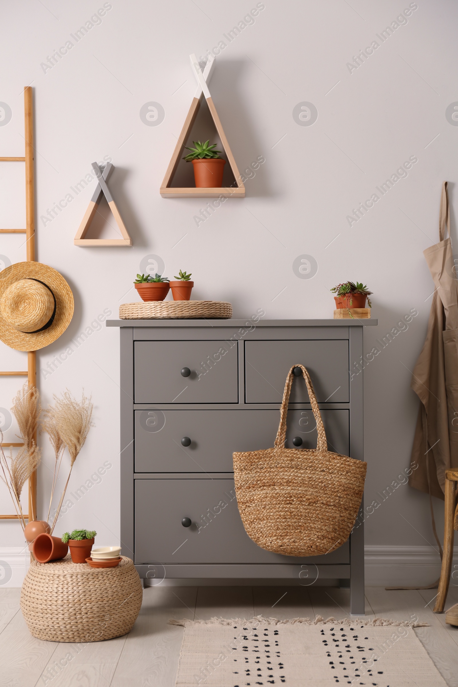 Photo of Grey chest of drawers in stylish room interior