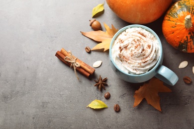 Flat lay composition with cup of pumpkin spice latte and space for text on gray table