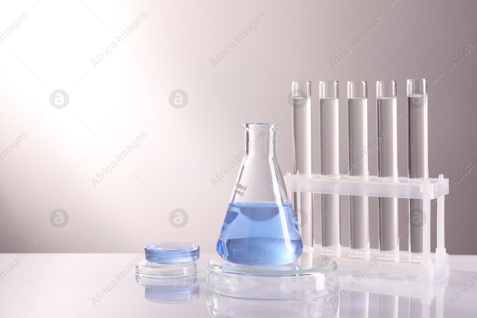 Photo of Laboratory analysis. Different glassware on table against light background, space for text