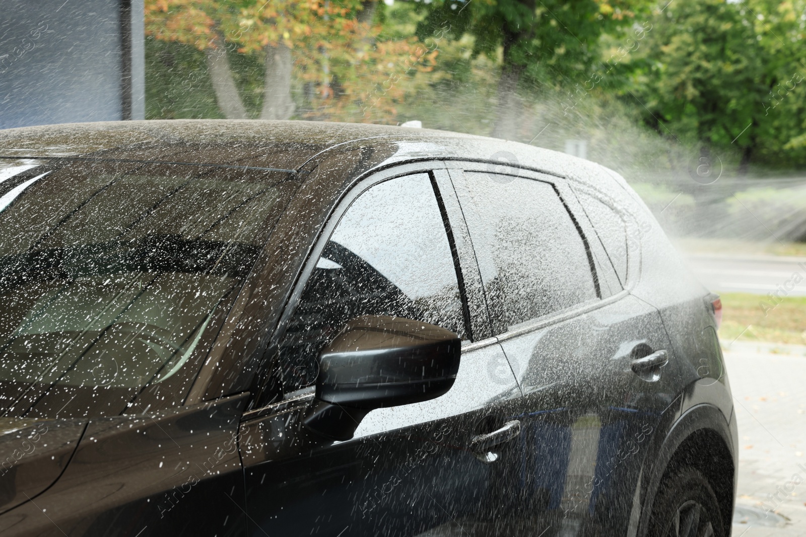 Photo of Washing auto with high pressure water jet at outdoor car wash