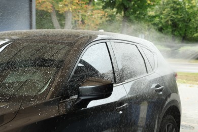 Photo of Washing auto with high pressure water jet at outdoor car wash