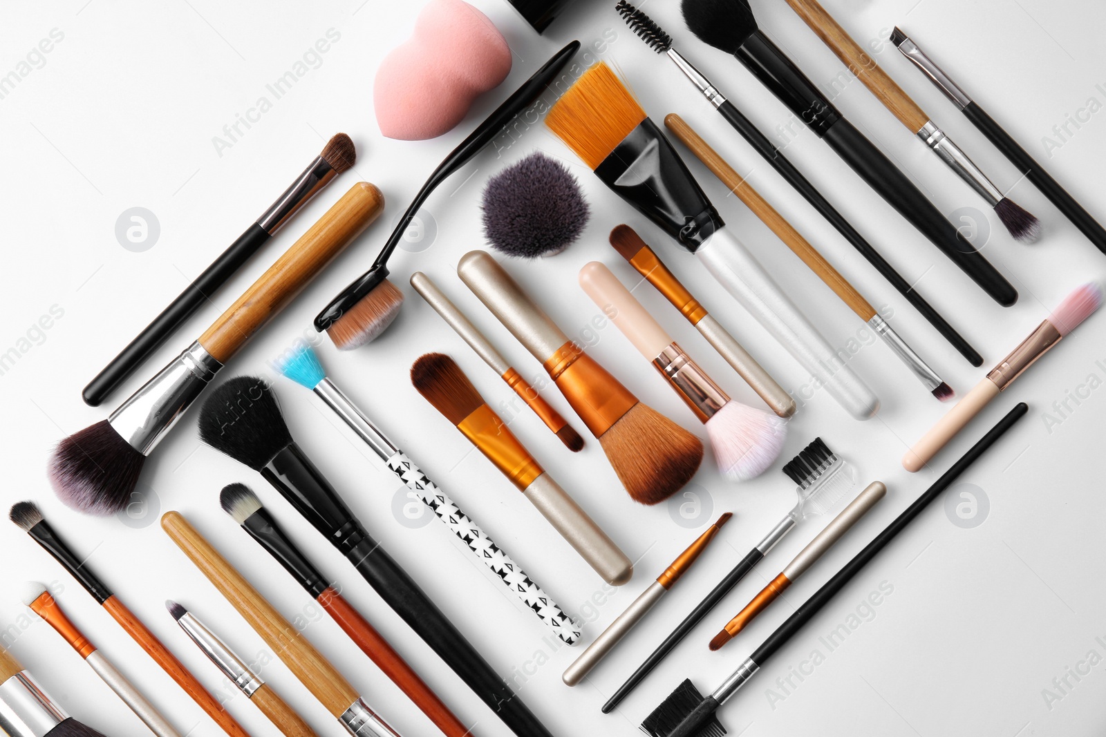 Photo of Flat lay composition with makeup brushes of professional artist on white background