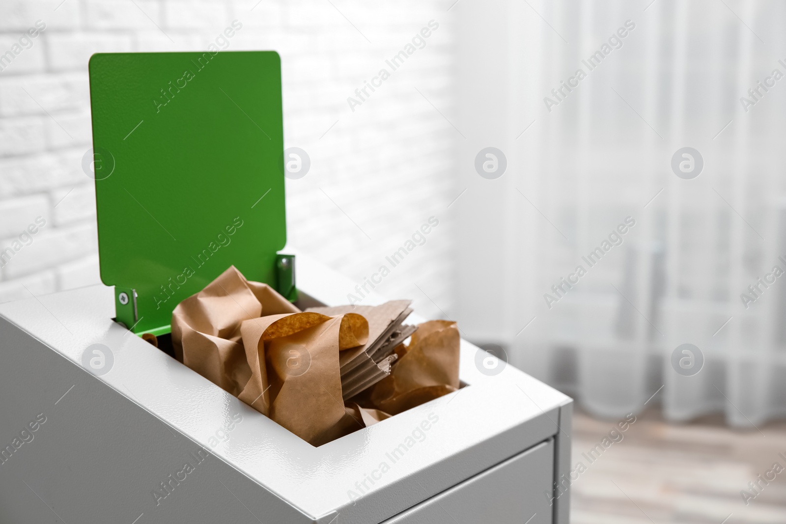 Photo of Trash bin with paper and cardboard indoors, space for text. Recycling concept
