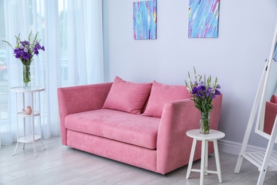 Modern interior of living room with comfortable sofa near white wall