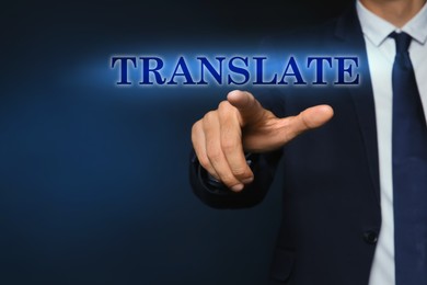 Image of Man pointing at virtual model of word TRANSLATE against dark blue background, closeup