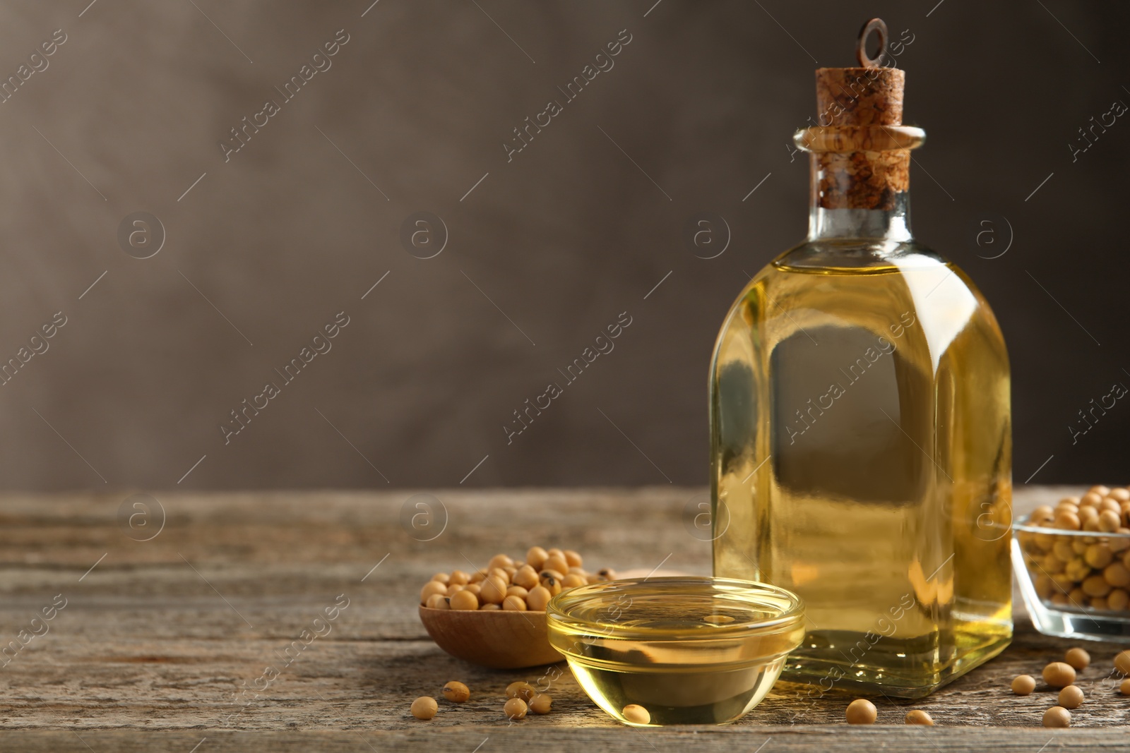 Photo of Composition with soybean oil on wooden table. Space for text