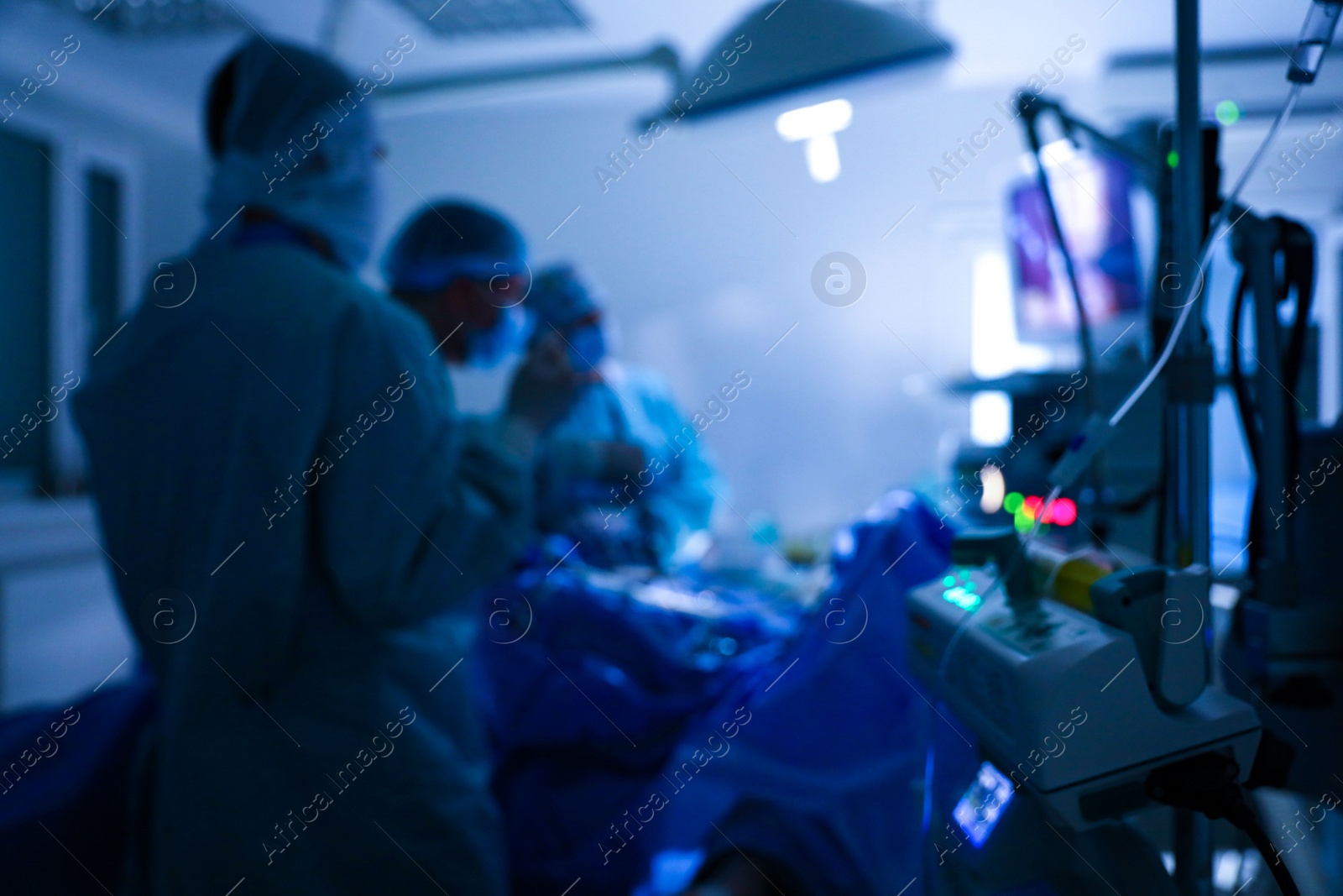 Photo of Blurred view of medical team performing surgery in operating room