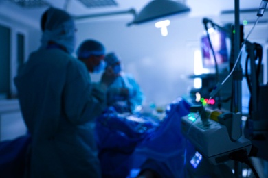 Photo of Blurred view of medical team performing surgery in operating room