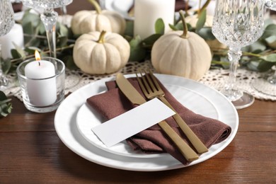 Photo of Beautiful autumn table setting. Plates, cutlery, blank card and floral decor
