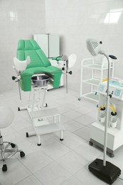 Photo of Modern gynecological office interior with examination chair and medical equipment