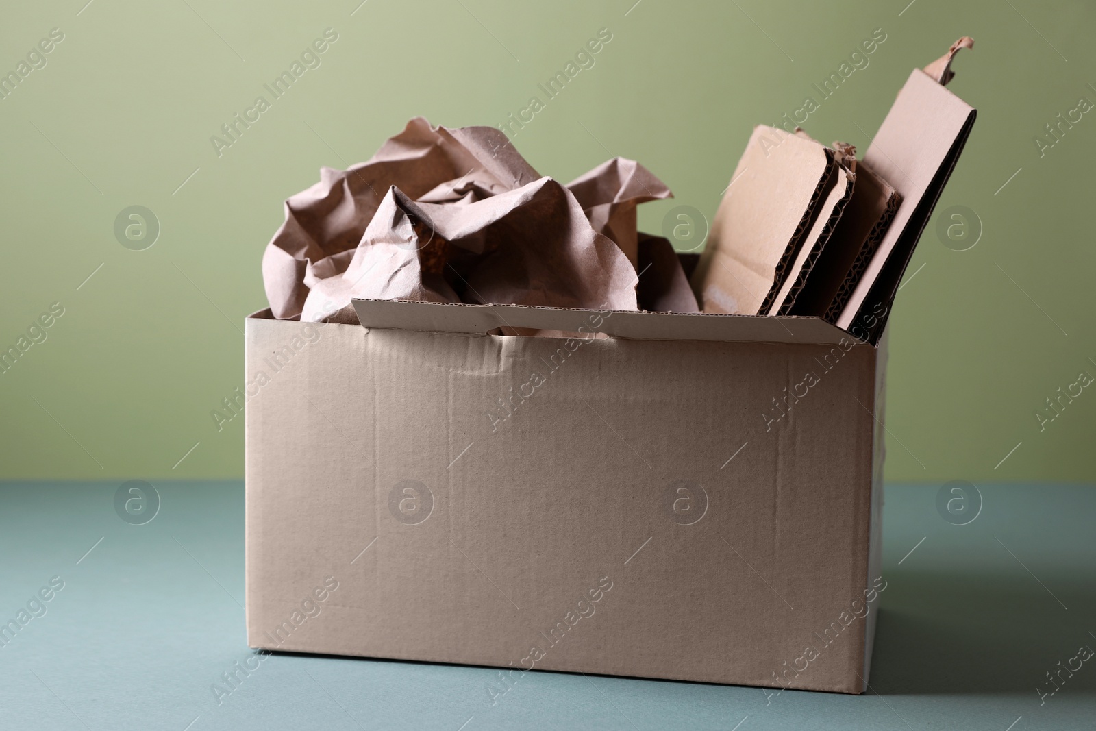 Photo of Box of waste paper on grey table