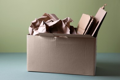 Box of waste paper on grey table