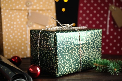 Photo of Composition with beautifully wrapped gift box on wooden table