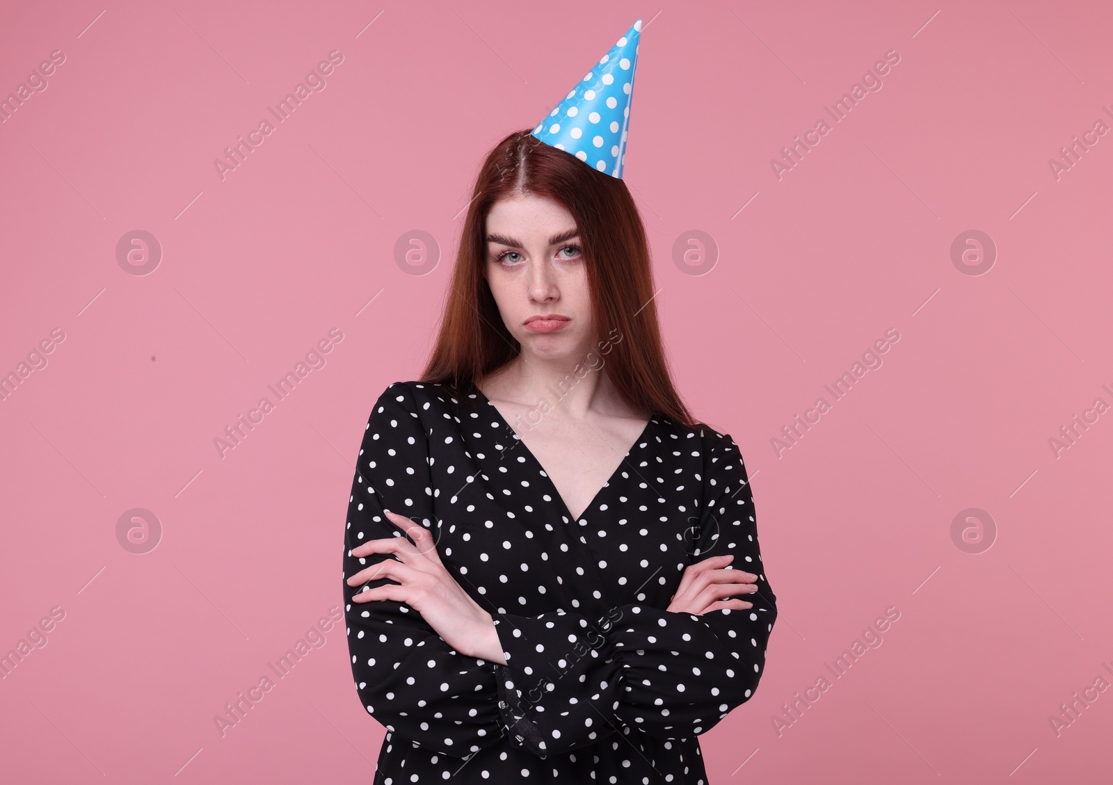 Photo of Sad woman in party hat on pink background